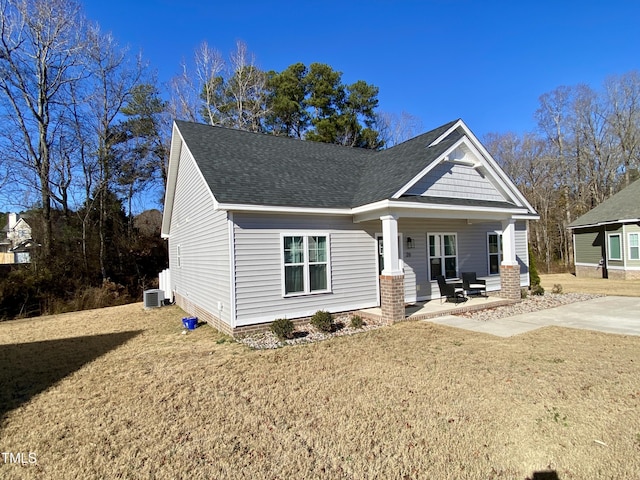 view of front of house with central AC unit, a porch, and a front lawn