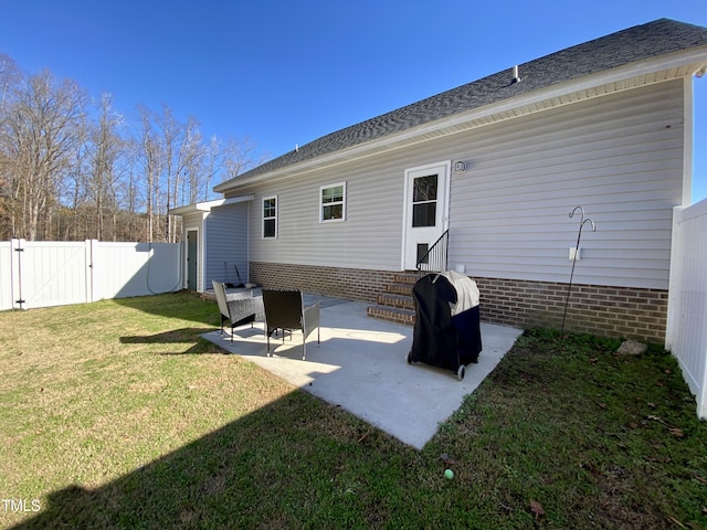 rear view of house featuring a lawn and a patio