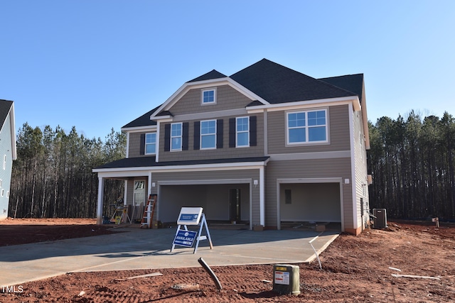 view of front of home featuring a garage and central air condition unit