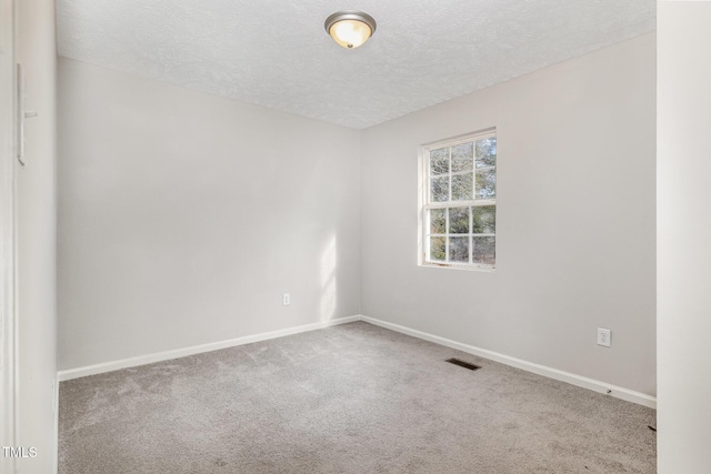 carpeted spare room with a textured ceiling