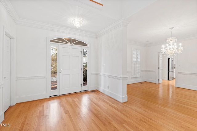 entryway with ornamental molding, light hardwood / wood-style flooring, and a chandelier