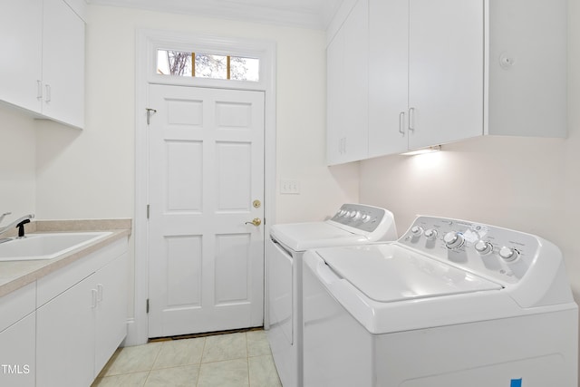 laundry area featuring cabinets, ornamental molding, washer and clothes dryer, sink, and light tile patterned floors