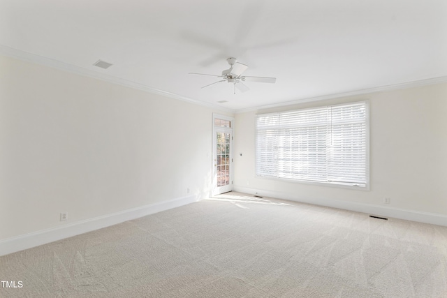 spare room with light carpet, ceiling fan, and crown molding