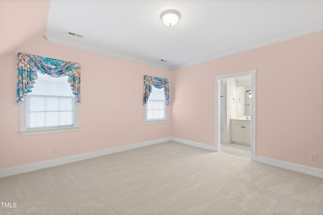 empty room featuring light carpet, a healthy amount of sunlight, lofted ceiling, and ornamental molding