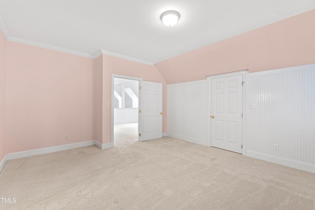 unfurnished bedroom with lofted ceiling, crown molding, and light carpet