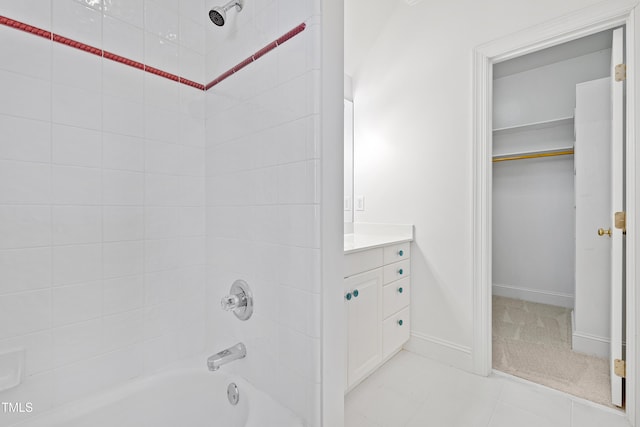 bathroom featuring tile patterned flooring, vanity, and tiled shower / bath