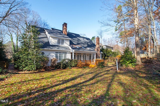 back of house with a deck and a yard