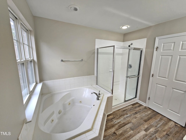 bathroom featuring plenty of natural light, wood-type flooring, and independent shower and bath