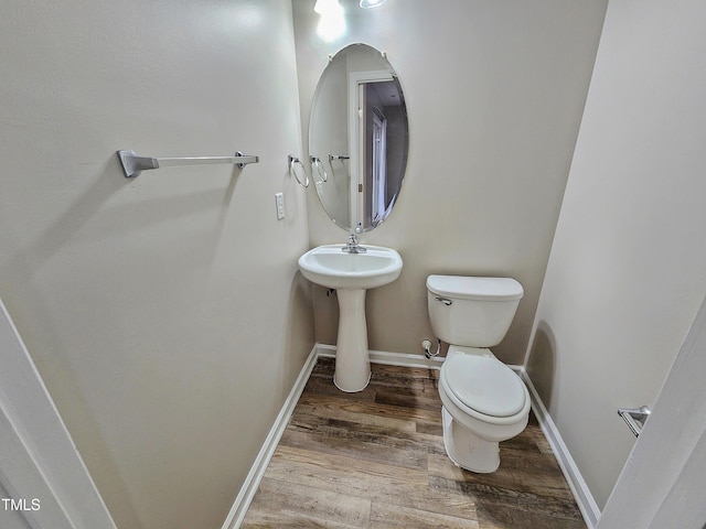 bathroom featuring toilet, wood-type flooring, and sink