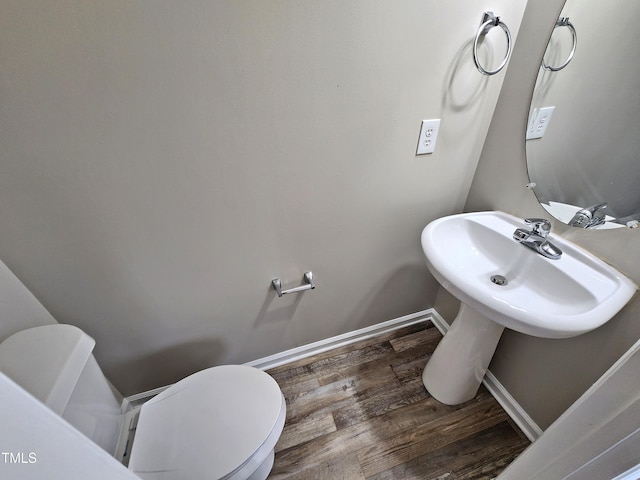 bathroom featuring hardwood / wood-style flooring, toilet, and sink