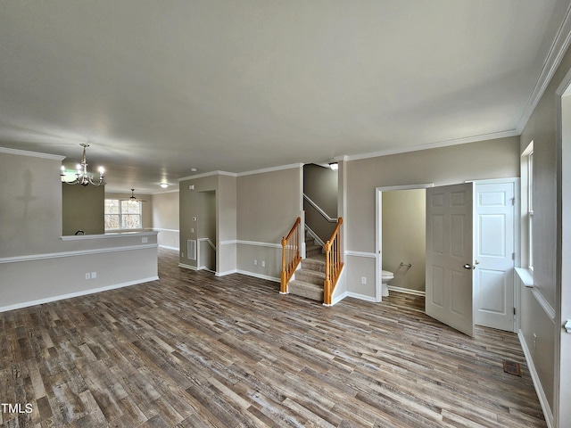 unfurnished living room featuring hardwood / wood-style flooring, crown molding, and an inviting chandelier