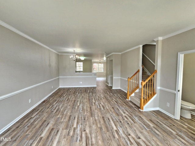 unfurnished living room with a chandelier, hardwood / wood-style flooring, and ornamental molding