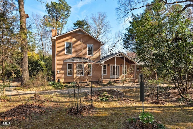 rear view of house featuring a chimney