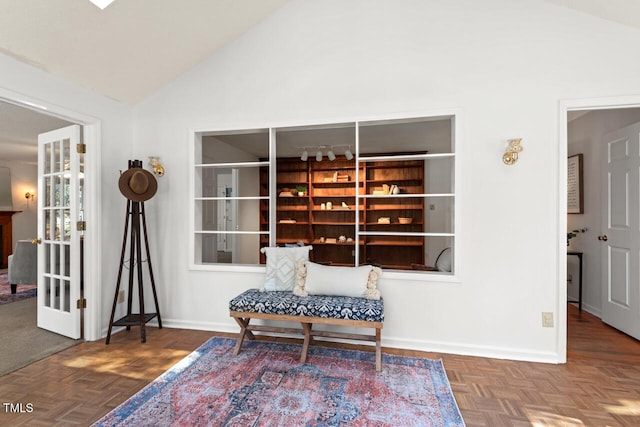 living area with baseboards and vaulted ceiling