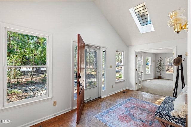 foyer featuring high vaulted ceiling, a skylight, and baseboards