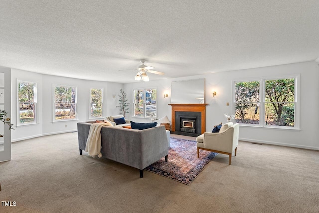 carpeted living area featuring a wealth of natural light, a fireplace with flush hearth, and visible vents