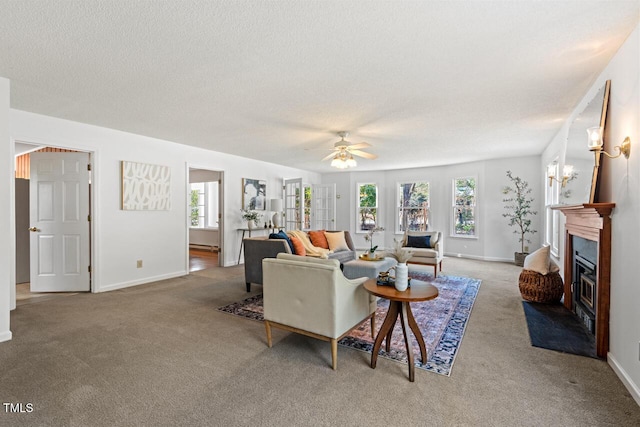 living area with carpet flooring, a fireplace with flush hearth, plenty of natural light, and a ceiling fan