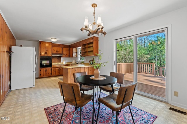 dining area featuring visible vents, light floors, and a chandelier