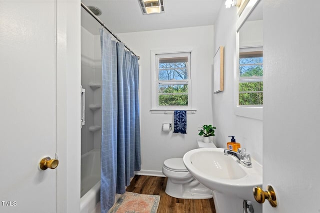 full bath with wood finished floors, visible vents, a sink, shower / bath combination with curtain, and toilet