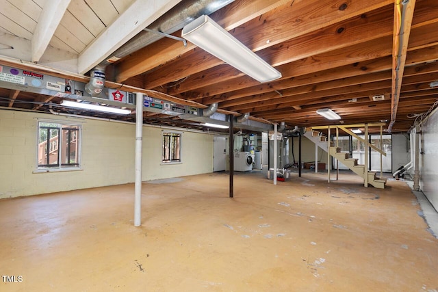 basement featuring stairway and concrete block wall