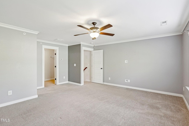 carpeted empty room with ceiling fan and ornamental molding