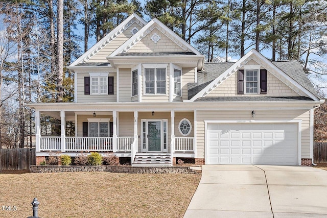 view of front of house featuring a garage, a front lawn, and covered porch