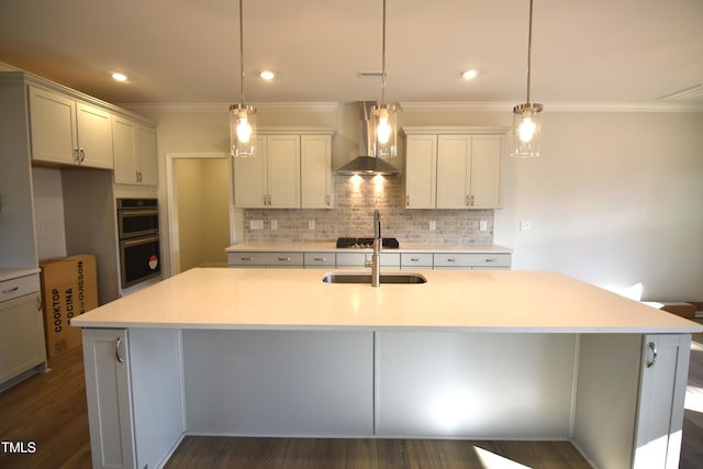 kitchen with wall chimney range hood, double oven, decorative backsplash, and a sink