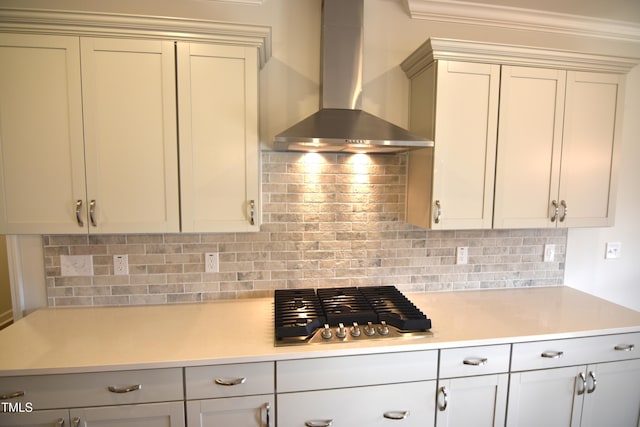 kitchen featuring stainless steel gas cooktop, wall chimney exhaust hood, tasteful backsplash, and light countertops