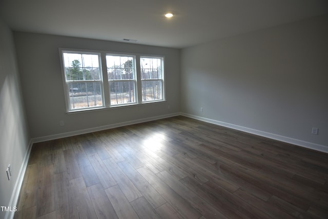 empty room with dark wood-style floors, baseboards, and recessed lighting