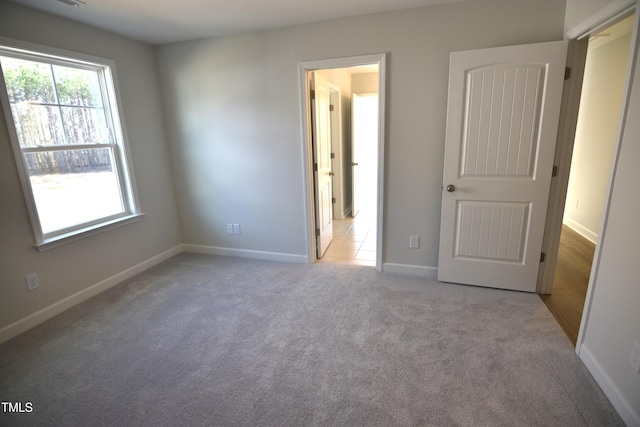 unfurnished bedroom featuring carpet floors and baseboards