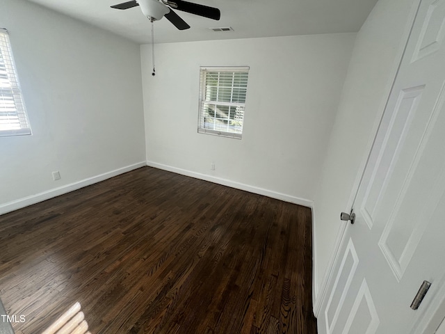 spare room with dark hardwood / wood-style floors, ceiling fan, and a wealth of natural light