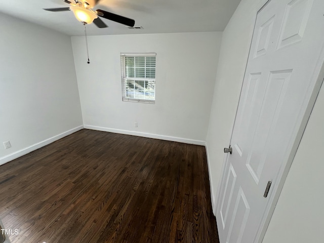 unfurnished room featuring ceiling fan and dark wood-type flooring