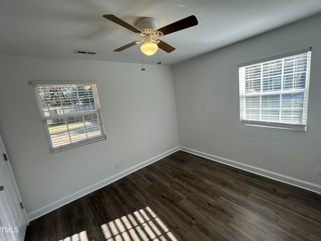 empty room featuring dark hardwood / wood-style floors, plenty of natural light, and ceiling fan