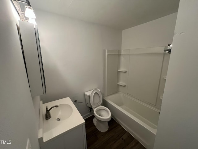 full bathroom featuring toilet, hardwood / wood-style floors, vanity, and washtub / shower combination