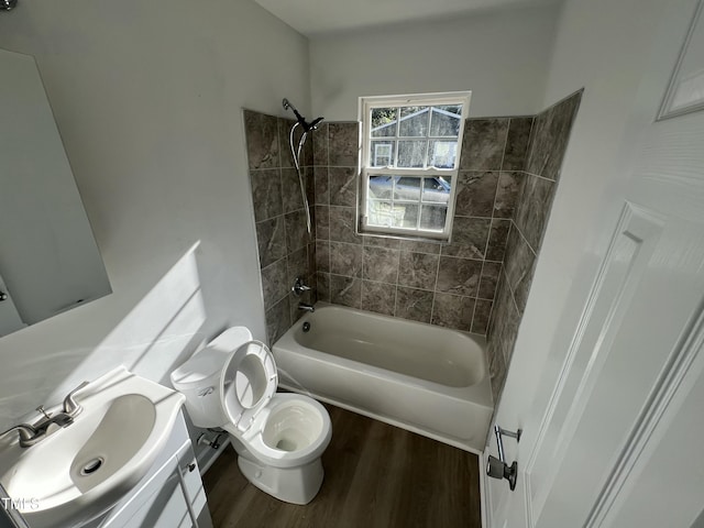 full bathroom with vanity, hardwood / wood-style floors, tiled shower / bath combo, and toilet