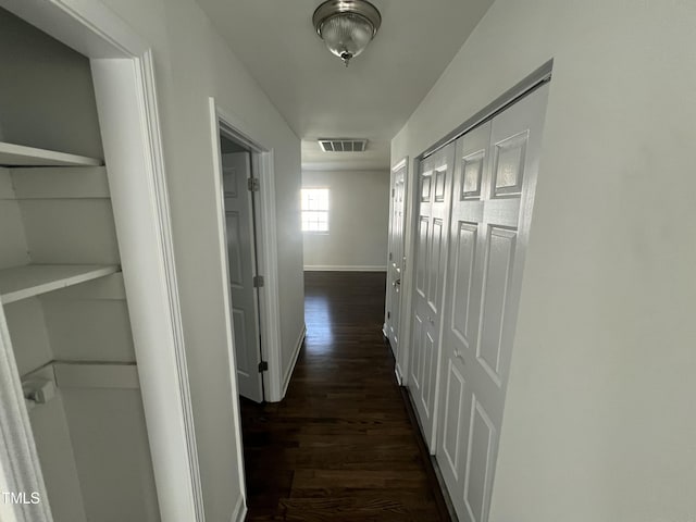 corridor featuring dark hardwood / wood-style floors and built in features