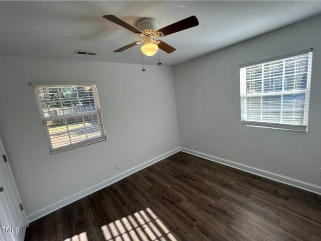 unfurnished room with dark hardwood / wood-style floors, ceiling fan, and a wealth of natural light