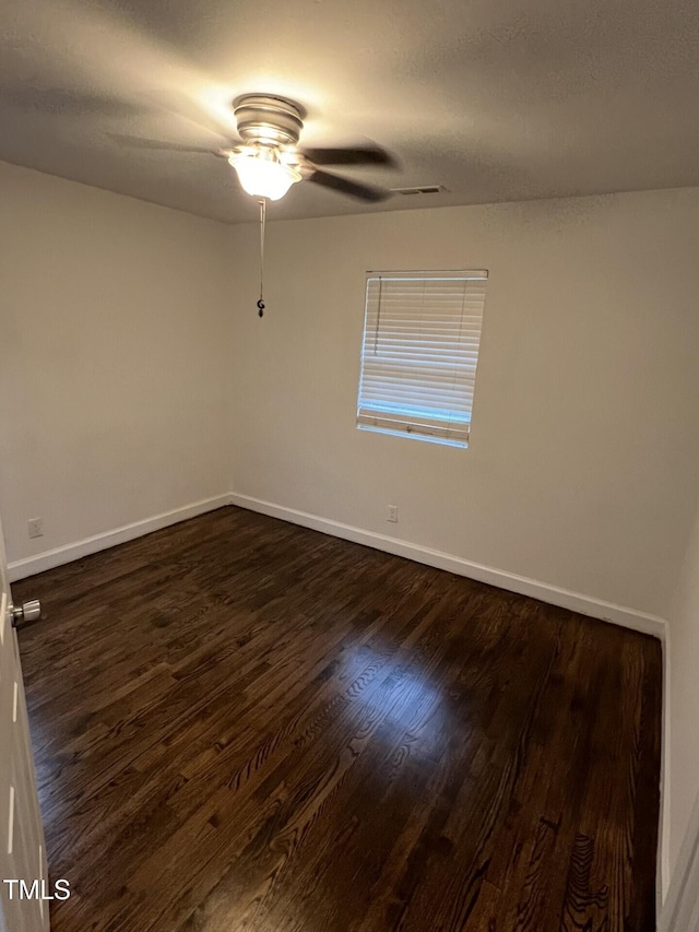 spare room with ceiling fan and dark hardwood / wood-style floors