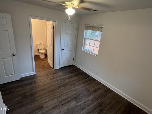 unfurnished bedroom with dark hardwood / wood-style flooring, ensuite bathroom, and ceiling fan