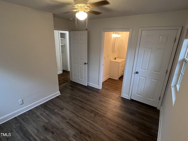 unfurnished bedroom featuring connected bathroom, ceiling fan, sink, and dark wood-type flooring