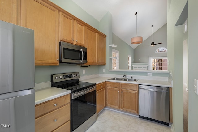 kitchen featuring ceiling fan, appliances with stainless steel finishes, decorative light fixtures, high vaulted ceiling, and sink