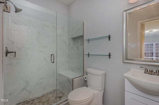 bathroom featuring a shower with door, toilet, and vanity