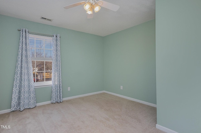 carpeted empty room featuring a textured ceiling, ceiling fan, and a healthy amount of sunlight