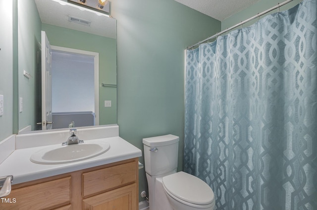 bathroom with toilet, vanity, a shower with shower curtain, and a textured ceiling