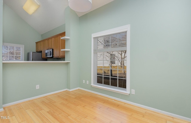 kitchen featuring light hardwood / wood-style floors, lofted ceiling, and stainless steel appliances