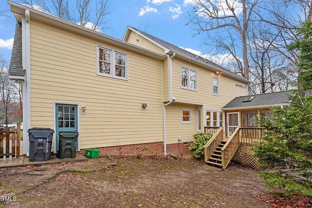 back of house with a wooden deck and a sunroom