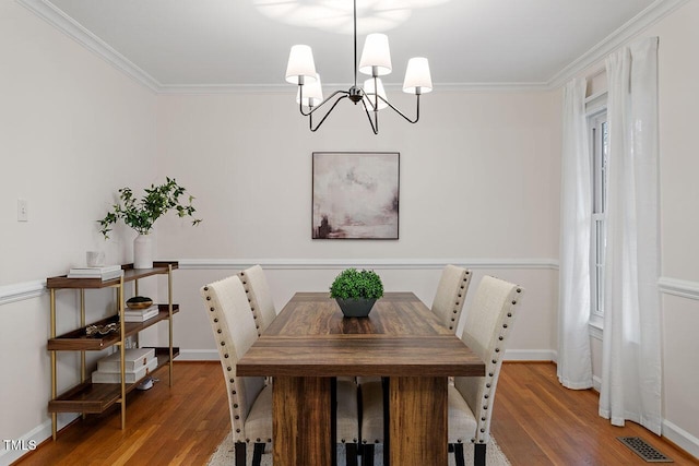 dining space featuring a notable chandelier, ornamental molding, and wood-type flooring