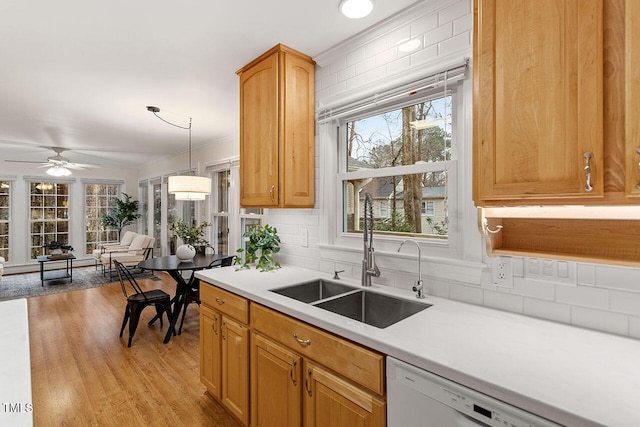 kitchen with ceiling fan, white dishwasher, a wealth of natural light, sink, and decorative light fixtures