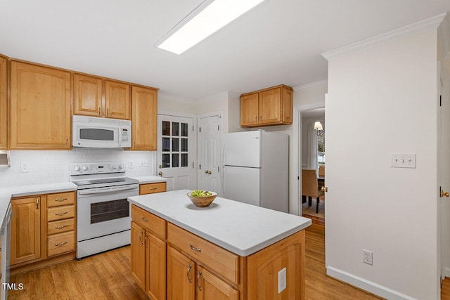 kitchen with white appliances, crown molding, a kitchen island, light hardwood / wood-style flooring, and backsplash