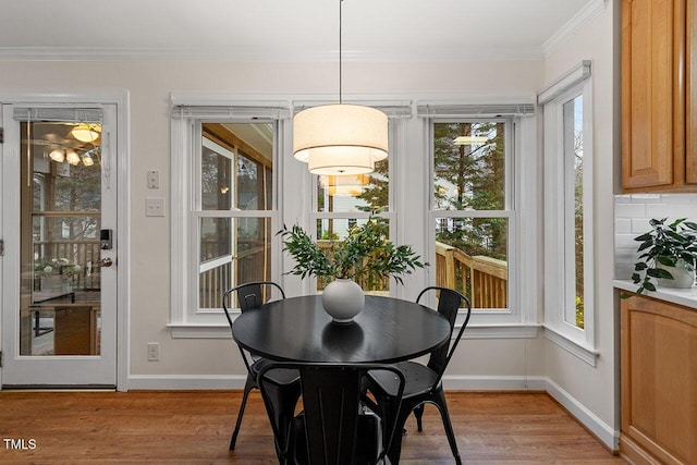 dining space featuring light hardwood / wood-style floors and crown molding